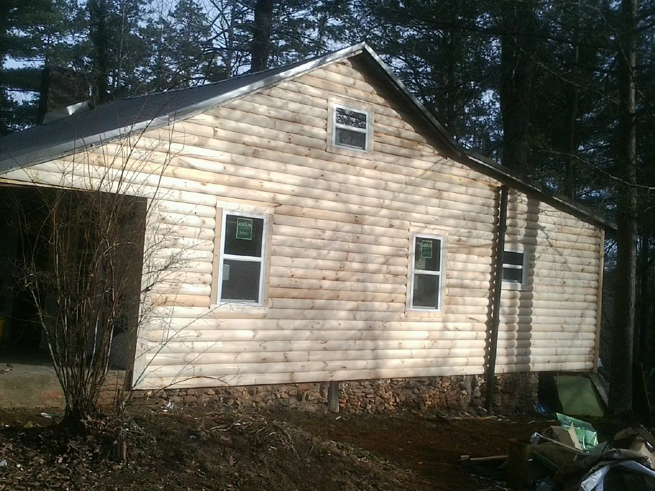 New log siding and dark metal roofing on a gable end in Columbiana