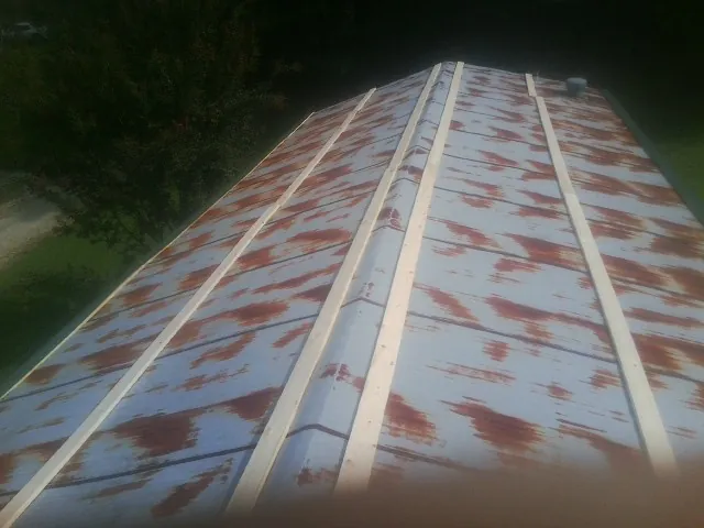 Rusted metal roof panels with new wood purlins before replacement — Storm Damage Roof Repair in Columbiana by Roofing Brothers